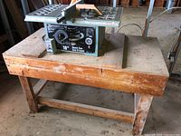 King 10 inch table saw placed on a worn wood work table in a workshop environment.