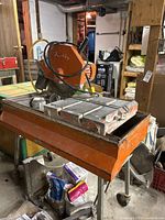 Front view of orange Tierre wet tile saw mounted on metal stand