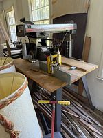 Full side view of the Craftsman 10-inch radial arm saw showing wooden tabletop, metal stand, yellow safety guard, and saw motor.