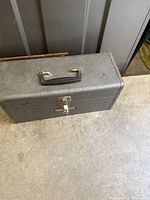 Closed gray metal Craftsman tool box with handle on top and latch on front
