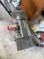 Top view of Craftsman router table showing metal table surface, ribbed aluminum fence, red plastic safety guard, and adjustable clamps with T-shaped handles.