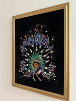 Side angled view of embroidered peacock artwork in gold frame showing depth and detail.