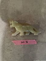 Photo showing top and side view of the carved onyx panther figure on a surface with lot label nearby.