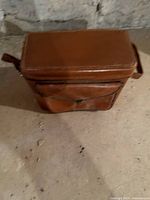 Front view of vintage brown leather camera case showing front pocket and overall condition