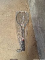 Photo of the vintage Wilson tennis racket sealed in clear plastic packaging, showing the full racket and label details.