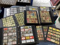 Top-down view of open binders showing plastic sleeves filled with colorful vintage matchbook covers