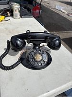 Front view of black Bakelite rotary dial telephone showing rotary dial with worn numbers and center with old telephone number 3-7902.