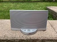 Front view of a silver Bose Sound Dock Series II speaker dock with mesh grille and central docking port for 30-pin Apple devices.