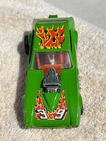 Top-down view of green Lesney Matchbox Speed King Racing Car showing flame decals, number 39 on hood and roof, exposed engine detail and orange interior.