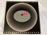 Front cover of the Queen Jazz vinyl LP record showing the album title in concentric circle design with pink 'Jazz' lettering.