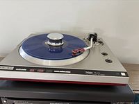Front view of Technics SL-1300MK2 turntable with blue disc on platter