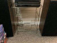 Full view of vintage metal record and stereo stand with a stereo component on top and speakers on either side.