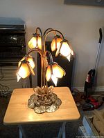 Front view showing brass base, five arched arms, and stained glass shades