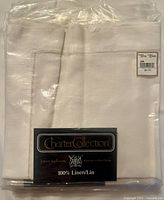 Original packaging showing folded white linen napkins with Hudson's Bay Charter Collection label.