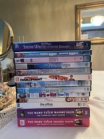 Stack of 13 assorted DVDs including animated movies, classic films, and TV series seasons.