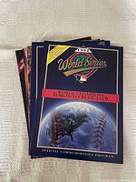 Stack of sports souvenir programs with 1992 World Series program on top featuring Toronto Blue Jays World Champions cover.