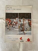 Official Home TV Program for the Moscow Series cover, dated September 22-28, 1972, featuring hockey players in action, issued by Jim Little Ford Sales, Richmond Hill. Logos of Team Canada and Hockey Canada present.