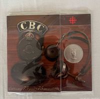 Front of commemorative coin and booklet in sealed plastic with CBC vintage radio graphics
