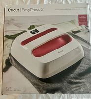Boxed Cricut EasyPress 2 9x9 with digital display and red handle visible on box front.