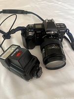 Minolta Maxxum 7000 camera with 50mm lens and Achiever 300AF flash on white background