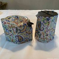 Teapot and matching tin side by side showing shape and paisley pattern