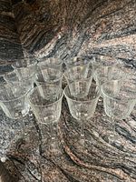 Photo showing all 12 ribbed crystal wine glasses arranged closely together on a granite countertop, highlighting quantity and consistency in design.