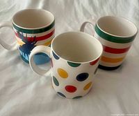 Three Hudson's Bay Stripe Collection ceramic mugs displayed together showing their different designs.