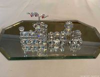 Front angle view of the three-piece Swarovski crystal train set on a mirrored base, showing locomotive and two cars.