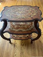 Top view showing intricate floral inlay design and scalloped edges.