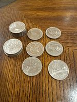 Photo showing all 15 Canadian dollar coins arranged in stacks and laid out, displaying various provincial designs and dates.