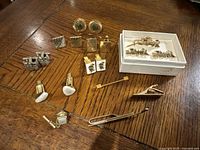 Full lot showing all cufflinks and tie clips on wooden surface