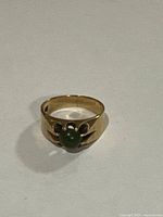Front view of ring showing band and green cabochon setting.