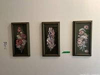 Three framed paper tole floral art panels mounted on a wall.