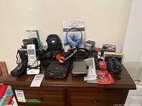 Overview of all items on a wooden surface showing phones, cameras, and audio equipment.