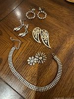 Photo showing the entire set laid out on a wooden surface including choker, earrings, and brooches.