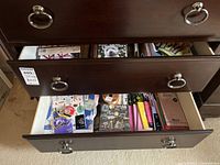 View of two wooden drawers opened showing assorted stationery items including wrapping papers, cards and tapes.