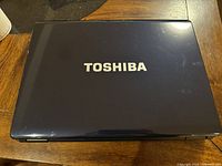 Closed top view of the Toshiba laptop with Toshiba logo on lid.