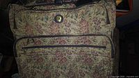 Front view floral tapestry luggage showing logo button, pockets