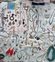 overview of entire lot spread on quilt including necklaces, bracelets, earrings, tiara
