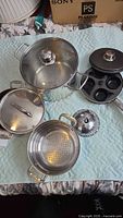 Full lot showing stockpot with lid, perforated insert, egg poacher pan with lid, folding steamer