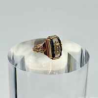 Front angled view of 10k gold signet ring showing crest and colored background details