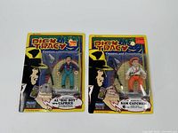 Two sealed Dick Tracy action figures in blister card packaging showing Al 'Big Boy' Caprice and Sam Catchem characters with colorful retro comic style graphics