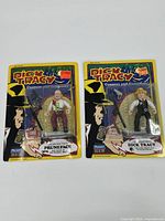 Two sealed Dick Tracy action figures, one labeled Pruneface, the other Dick Tracy, both in original packaging with accessories visible.
