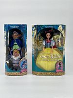 Front view of the two boxed Mattel Disney Snow White toys showing Snow White doll and Dopey & Sneezy stackable dolls.