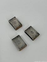 Top view of three sterling silver matchboxes showing monogrammed tops.