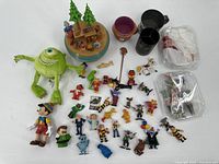 Lot of 41 vintage toy figurines and plush toys arranged on white surface.