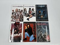 6 graphic novels laid flat including Morning Glories volumes 1 and 2, Wraithborn, Scarlet, Witchblade, and Sigil: The Marked Man.