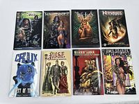 Eight graphic novels arranged in two rows, showing front covers with fantasy/sci-fi artwork