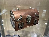 Copper color decorative chest with silver accent decorations and latch, curved lid