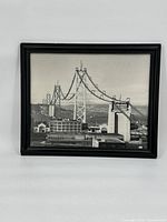 Full view of the framed print showing the Bay Bridge under construction, including bridge towers and suspension cables.